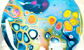 rond dienblad met acryl erop in de kleuren geel, oranje, blauw, rood, paars en wit